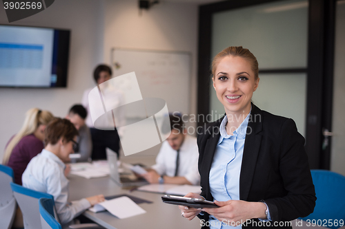 Image of business woman working on tablet at meeting room