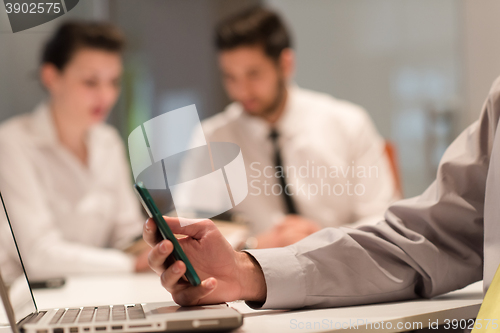 Image of close up of  businessman hands  using smart phone on meeting