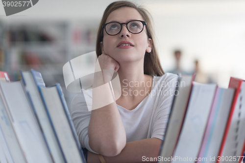 Image of portrait of famale student selecting book to read in library