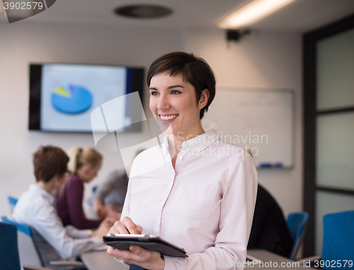 Image of hispanic businesswoman with tablet at meeting room