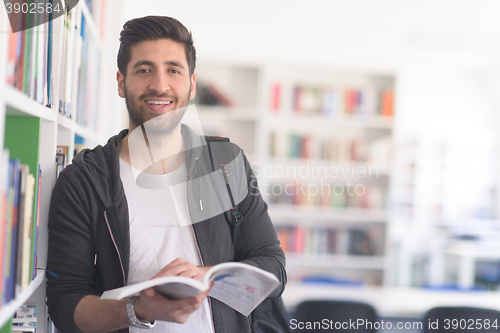 Image of portrait of student while reading book  in school library