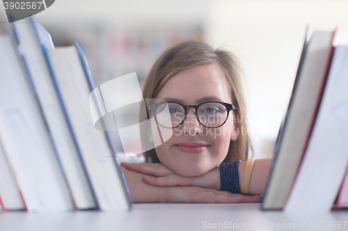 Image of portrait of famale student selecting book to read in library