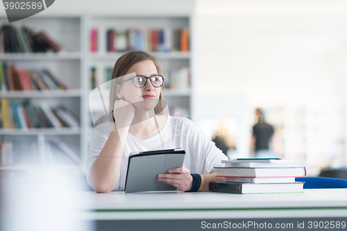 Image of student with tablet in library