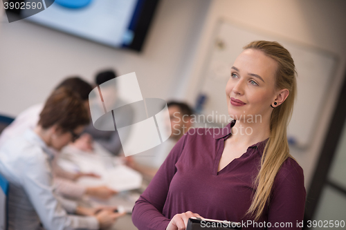 Image of blonde businesswoman working on tablet at office