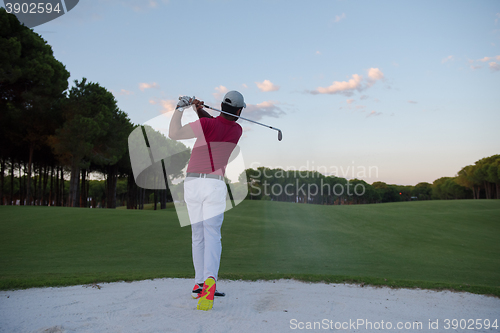 Image of golfer hitting a sand bunker shot on sunset