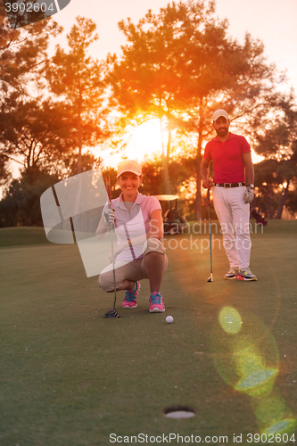 Image of couple on golf course at sunset