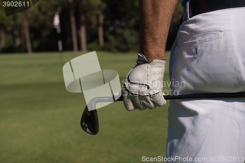 Image of golf player close up hand and driver from back