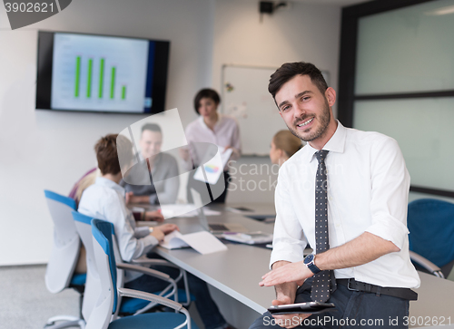 Image of young business man with tablet at office meeting room