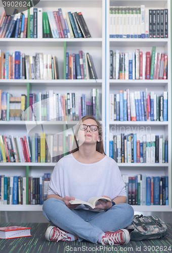 Image of famale student reading book in library