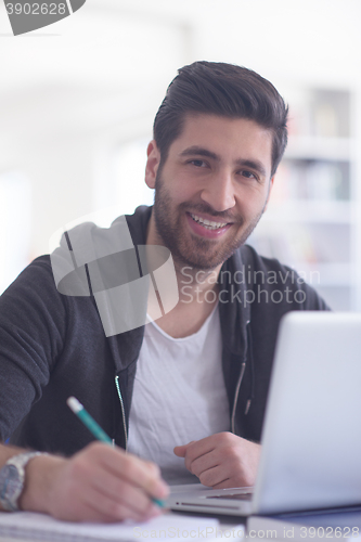 Image of student in school library using laptop for research