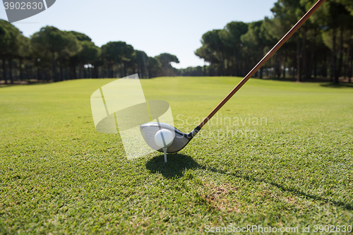 Image of golf player placing ball on tee