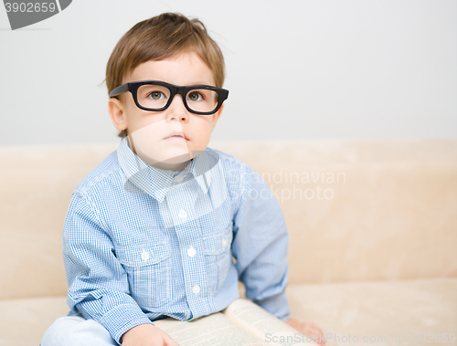 Image of Little boy is reading book