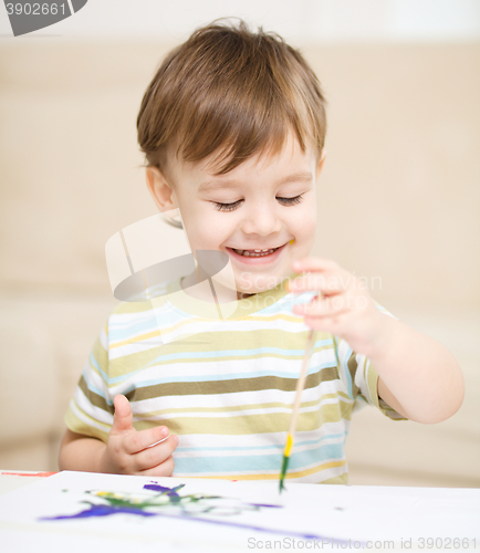 Image of Little boy is playing with paints