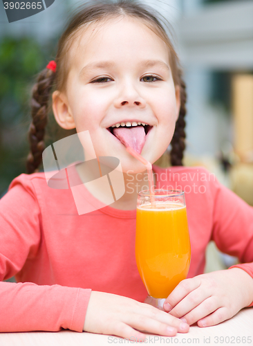 Image of Little girl is drinking orange juice