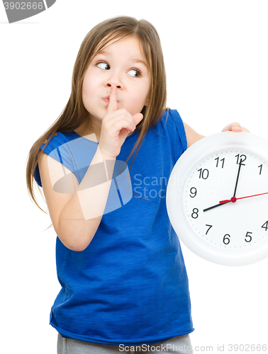 Image of Little girl is holding big clock