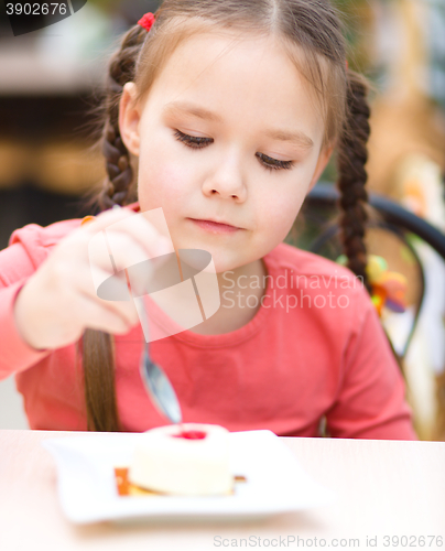 Image of Little girl is eating cake in parlor