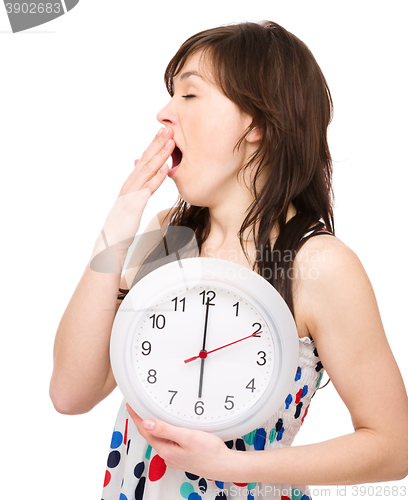 Image of Young woman is holding big clock