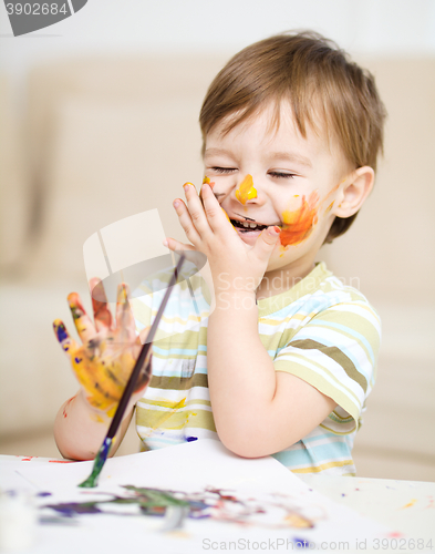 Image of Little boy is playing with paints