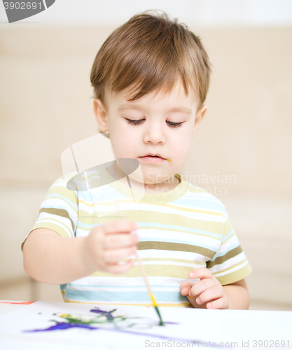 Image of Little boy is playing with paints