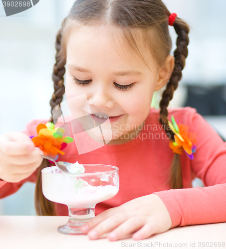 Image of Little girl is eating ice-cream in parlor