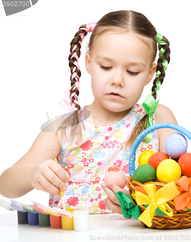 Image of Little girl is painting eggs preparing for Easter