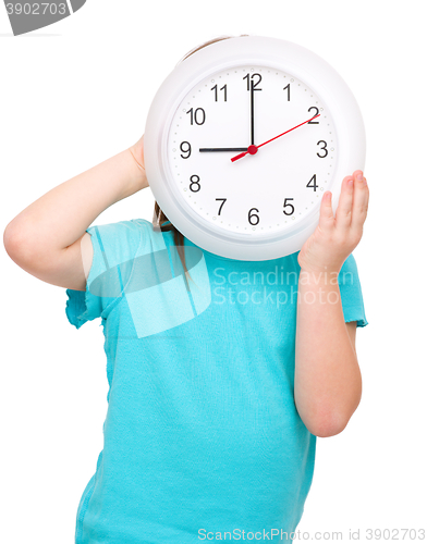 Image of Little girl is holding big clock