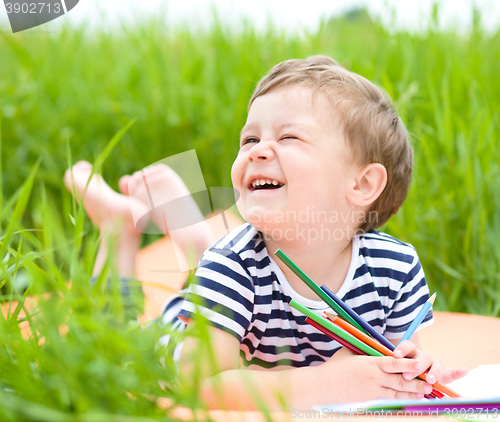 Image of Little boy is playing with pencils