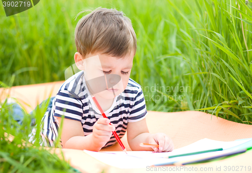 Image of Little boy is playing with pencils