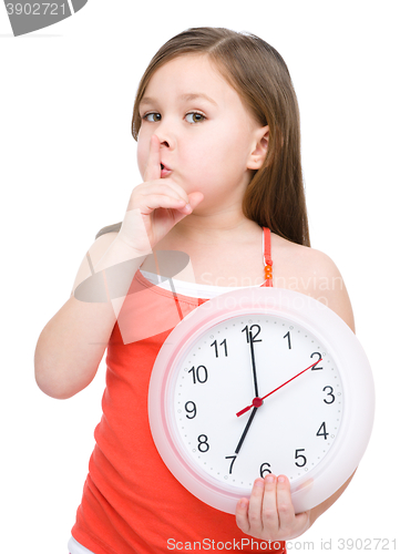 Image of Little girl is holding big clock