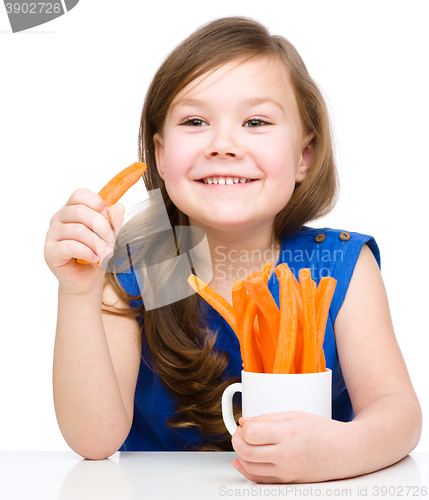Image of Cute little girl is eating carrot