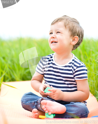 Image of Little boy is playing with toys