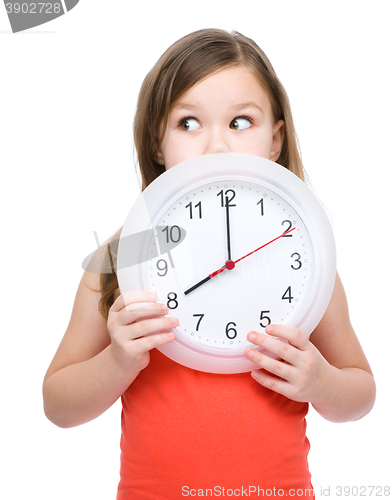 Image of Little girl is holding big clock