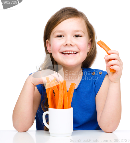 Image of Cute little girl is eating carrot