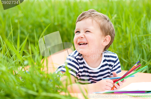 Image of Little boy is playing with pencils