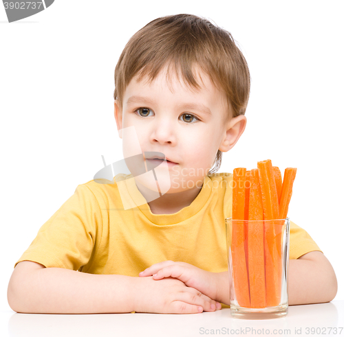 Image of Little boy is eating carrot