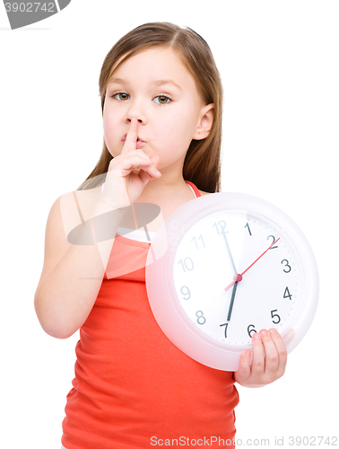 Image of Little girl is holding big clock