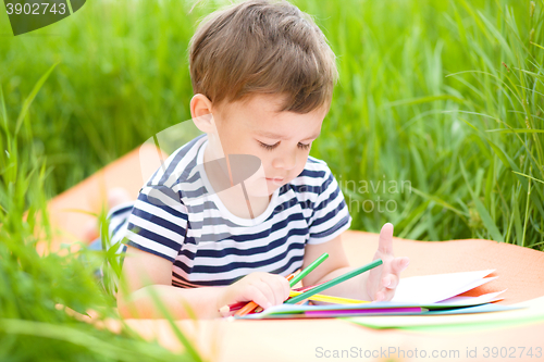 Image of Little boy is playing with pencils