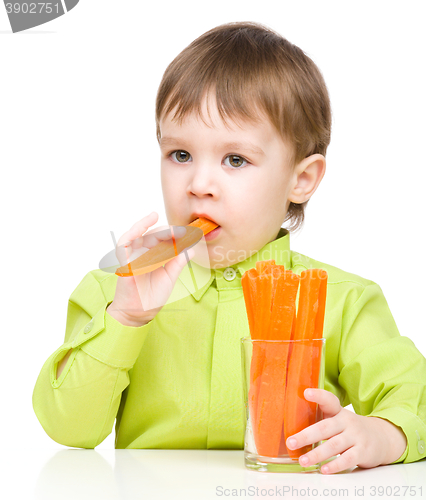 Image of Little boy is eating carrot