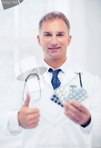 Image of young male doctor with packs of pills