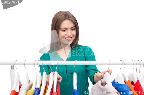 Image of happy woman choosing clothes at home wardrobe