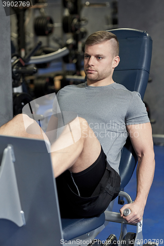 Image of man flexing leg muscles on gym machine