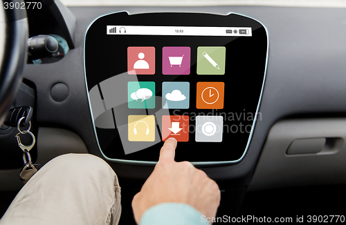 Image of close up of hand and menu icons on car computer