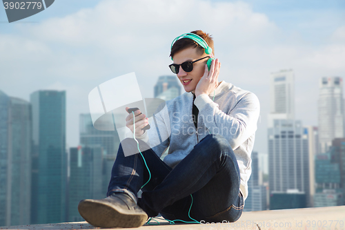 Image of happy young man in headphones with smartphone