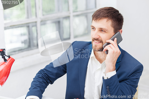 Image of Portrait of businessman talking on phone in office