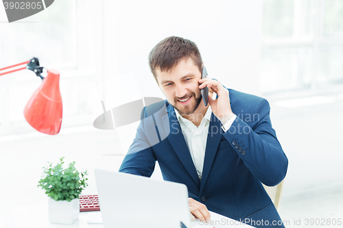 Image of Portrait of businessman talking on phone in office