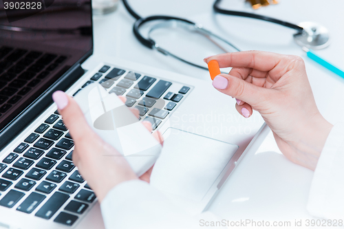 Image of The hands of doctor woman writing at the medical office