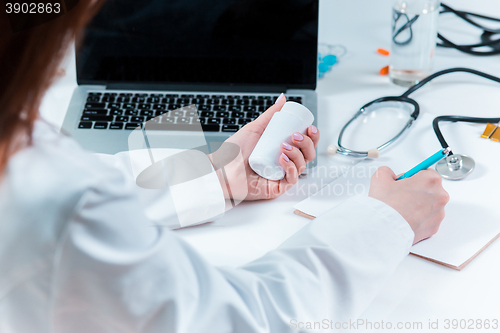 Image of The hands of doctor woman writing at the medical office