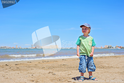 Image of Cute small boy standing on the beach