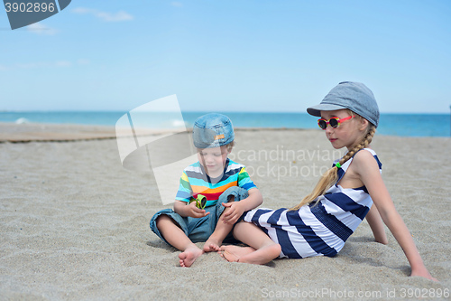 Image of Two small kids sitting on the beach
