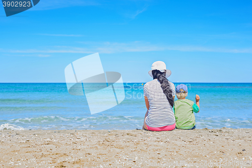 Image of Brunette with long hair and kid turned away